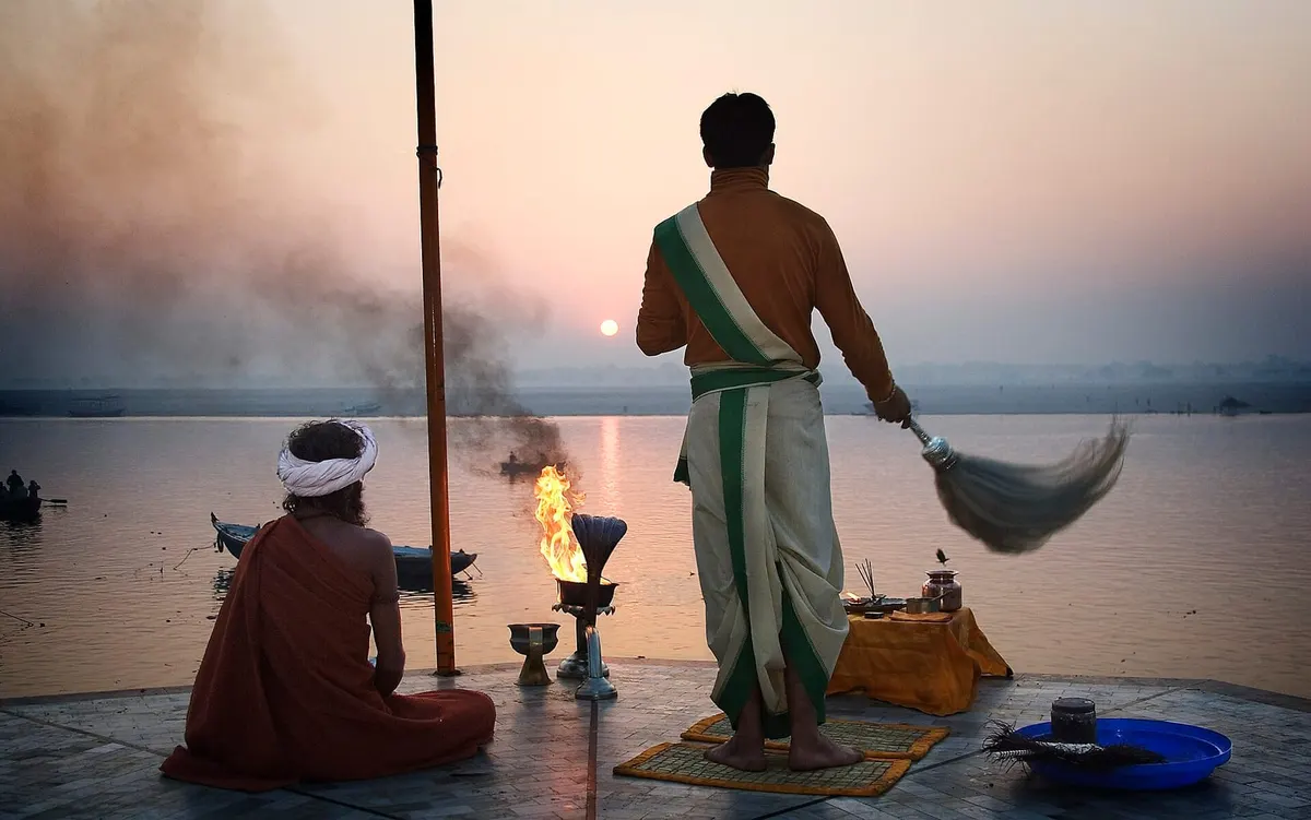 Priests performing dawn fire ritual on a Varanasi ghat as the sun rises