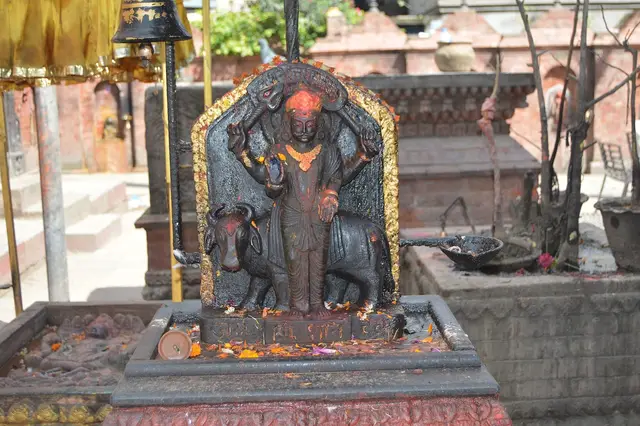 Black stone Shani Dev idol smeared with vermilion at a Kathmandu temple