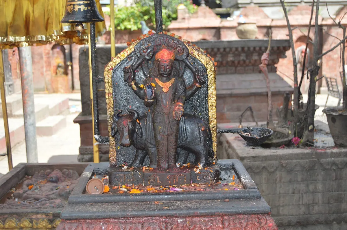 Black stone Shani Dev idol smeared with vermilion at a Kathmandu temple